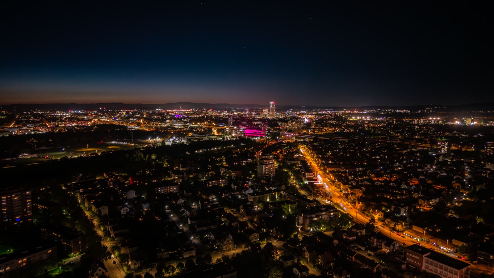 Golden hour magic - aerial view during evening with warm sunset light painting the Swiss landscape in orange and amber tones