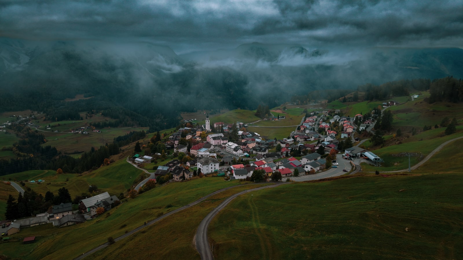 Golden morning light illuminating Swiss countryside with dramatic shadows and warm atmospheric glow from drone perspective